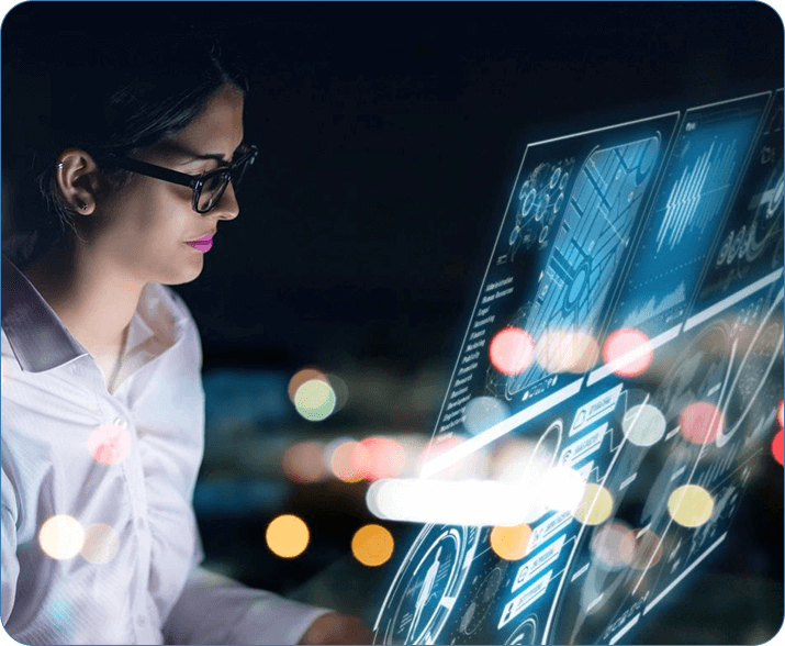 A woman in glasses looking at a computer screen.